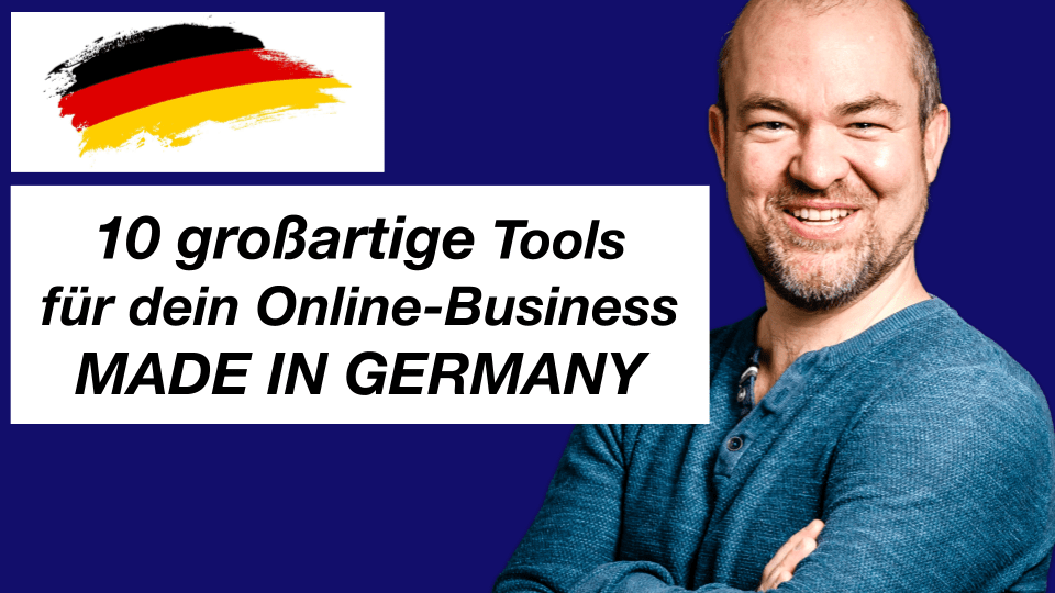 Ein lächelnder Mann steht mit verschränkten Armen neben einer Grafik mit der deutschen Flagge und dem Text "10 großartige Tools für dein Online-Business MADE IN GERMANY" auf einem dunkelblauen Hintergrund.
